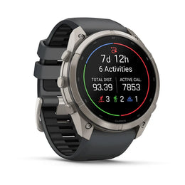A Garmin smartwatch with a round silver-tone case and a dark gray silicone strap, shown on a clean white background. The watch face is illuminated with a black screen displaying fitness metrics.