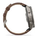 A side profile view of a smartwatch with a brown leather strap and a metallic gray case, shown against a plain white background.