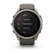 A Garmin smartwatch with a round silver-tone metal case and a dark gray silicone strap, shown against a plain white background. The watch face is on and displaying a list of activities including MTB, Trail Run, Row Indoor, Rucking, and Ski.