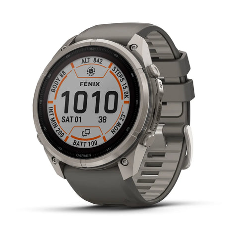 A Garmin Fenix smartwatch with a round silver titanium case and a dark gray silicone strap, shown at a three-quarter angle on a white background.
