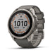 A Garmin Fenix smartwatch with a round silver titanium case and a dark gray silicone strap, shown at a three-quarter angle on a white background.