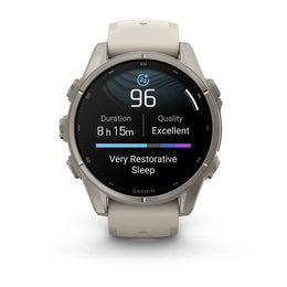 A Garmin smartwatch with a round silver-toned metal case and a light beige silicone strap, shown on a clean white background. The watch face is illuminated with a sleep tracking screen displaying 'Very Restorative Sleep' and a heart rate reading of 96.