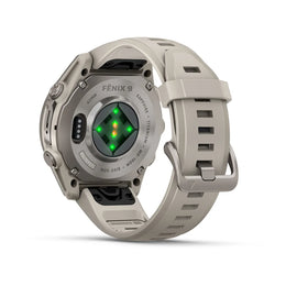 A rugged smartwatch shown from the back, featuring a matte gray-beige silicone strap and case with a metallic gray bezel. The center of the back displays a green and orange LED light pattern, and the brand name 'FENIX 9' is printed on the bezel.