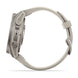 A side profile view of a smartwatch with a metallic silver case and a light beige or off-white silicone strap, shown against a solid white background.
