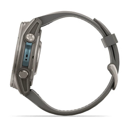 A side profile view of a rugged smartwatch with a dark gray silicone strap and a metallic gray case featuring a blue accent on the side buttons.