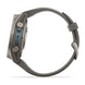 A side profile view of a rugged smartwatch with a dark gray silicone strap and a metallic gray case featuring a blue accent on the side buttons.
