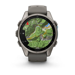 A Garmin smartwatch with a dark gray metallic case and matching dark gray silicone strap, shown on a clean white background. The watch face is active with a green topographic map display.