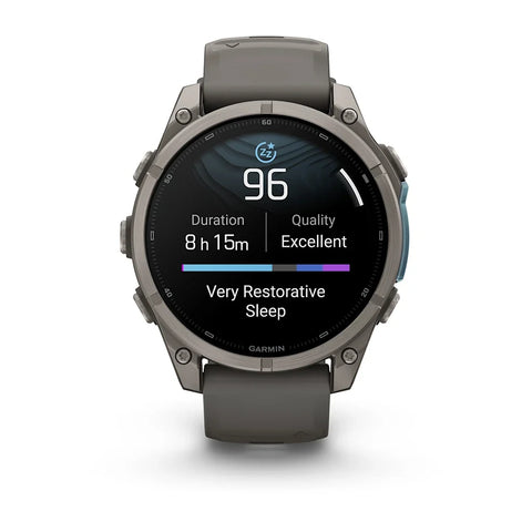 A Garmin smartwatch with a dark gray metallic case and a matching dark gray strap, shown against a plain white background. The watch face is illuminated with a sleep tracking app screen.