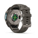 A rugged smartwatch shown from the back on a clean white background, featuring a dark gray silicone strap, a metallic gray case, and a green-lit circular sensor on the back.