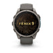 A Garmin Fenix 9 smartwatch with a dark gray metallic case and a matching dark gray silicone strap, shown against a plain white background. The watch face displays a black background with gold topographic contour lines and the text 'FENIX 9' in gold.