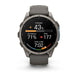 A Garmin smartwatch with a dark gray silicone strap and a metallic gray round case, shown on a clean white background. The watch face is active with various fitness and heart rate metrics displayed.