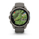 A Garmin smartwatch with a dark gray silicone strap and a metallic dark gray case, shown on a clean white background. The watch face is active with a green topographic map display.