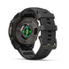 A rugged black smartwatch with a matching black silicone strap, shown from a three-quarters angle. The back of the watch face features a circular sensor area with green illuminated LED lights and the text 'FENIX 9'.
