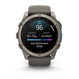 A Garmin smartwatch with a dark gray metallic case and matching dark gray strap, shown on a clean white background. The watch face displays sleep tracking information.