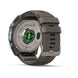 A rugged smartwatch shown from the back on a clean white background, featuring a dark gray resin strap and case with a metallic silver titanium backplate. The backplate displays 'FENIX 9' and 'SAMSUNG' along with a green LED heart rate sensor.