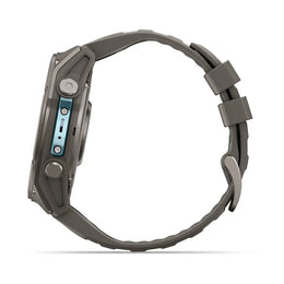 A rugged smartwatch shown from the side profile, featuring a dark gray textured silicone strap and a dark gray metallic case with a light blue accent on the side buttons.