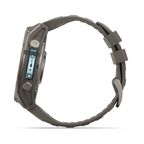 A rugged smartwatch shown from the side profile, featuring a dark gray textured silicone strap and a dark gray metallic case with a light blue accent on the side buttons.