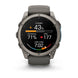 A Garmin smartwatch with a dark gray metallic case and a dark gray strap, shown on a clean white background. The watch face is active with various fitness and heart rate metrics displayed.