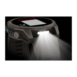 A rugged smartwatch with a circular display, textured dark gray body, and a bright white front light turned on, casting a beam of light downward. A solar panel graphic is visible on the top of the watch face against a black background.