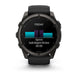 A Garmin smartwatch with a black and dark gray rugged case and black strap, shown against a plain white background. The watch face displays a fitness screen with a sprint graphic and text.