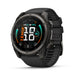 A black Garmin Fenix smartwatch with a round analog-digital display and a textured black strap, shown at a three-quarter angle on a white background.