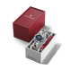 Silver watch with blue face in a white box, next to a red Victorinox box on a black background