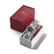 Silver watch with blue face in a white box, next to a red Victorinox box on a black background