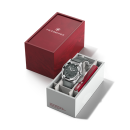 Silver watch with blue face in a white box, next to a red Victorinox box on a black background