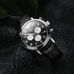 Black wristwatch with a detailed face on a dark textured background