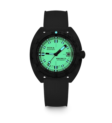 A black DOXA Submariner watch with a glowing green dial and black strap, shown against a plain white background.