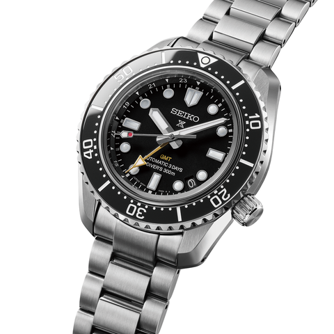 Seiko watch with black dial and silver metal bracelet on a white background