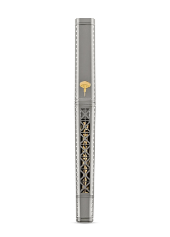 A luxury fountain pen with a silver-gray body, featuring intricate gold-toned filigree detailing on the barrel and a small gold-toned emblem near the top, set against a solid white background.