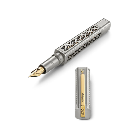 A silver-toned fountain pen with an intricate geometric cutout pattern on the barrel, shown with its cap removed and placed below. The pen features a gold-tone nib and a gold accent panel on the cap with the text 'James Bond' and '007'.