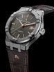 Luxury watch with brown leather strap and silver case on black background