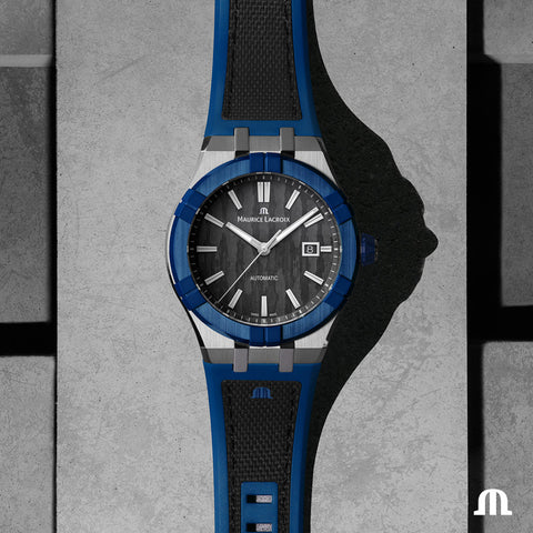 Maurice Lacroix watch with black and blue strap on a textured gray background