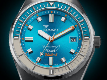 Squale watch with blue dial and silver case on a dark background