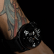 Black wristwatch with visible brand logo on a tattooed arm