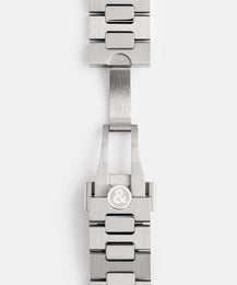 Close-up of a silver watch strap with a brand logo on a white background