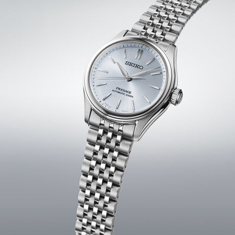 Silver Seiko watch with a metallic band on a light gray background