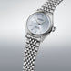 Silver Seiko watch with a metallic band on a light gray background