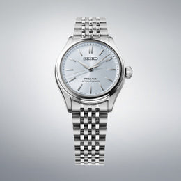 Silver Seiko watch on a gray background