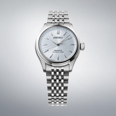 Silver Seiko watch on a gray background