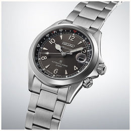 Silver Seiko watch with a dark face on a light gray background