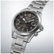 Silver Seiko watch with a dark face on a light gray background