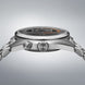 Close-up of a silver watch with detailed design on a gray background