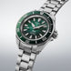 Seiko watch with green dial and silver metal bracelet on a light gray background