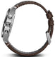 Close-up of a watch with a brown leather strap and silver case on a white background