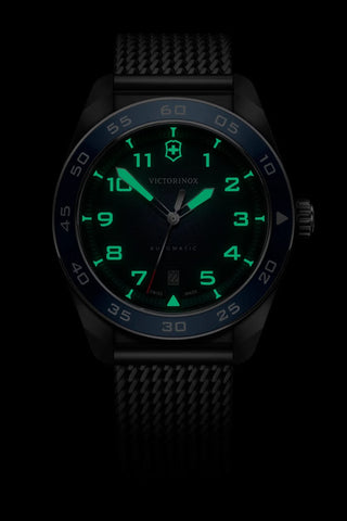 Victorinox watch with green glowing face on a black background